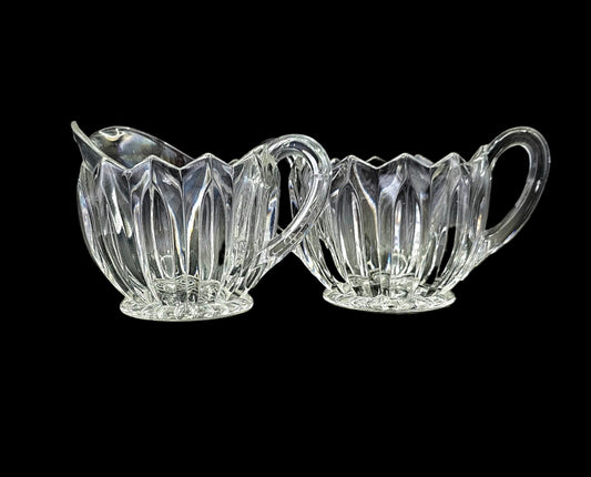 Glass sugar and creamer set, with handles, scalloped edge, and fluted sides.