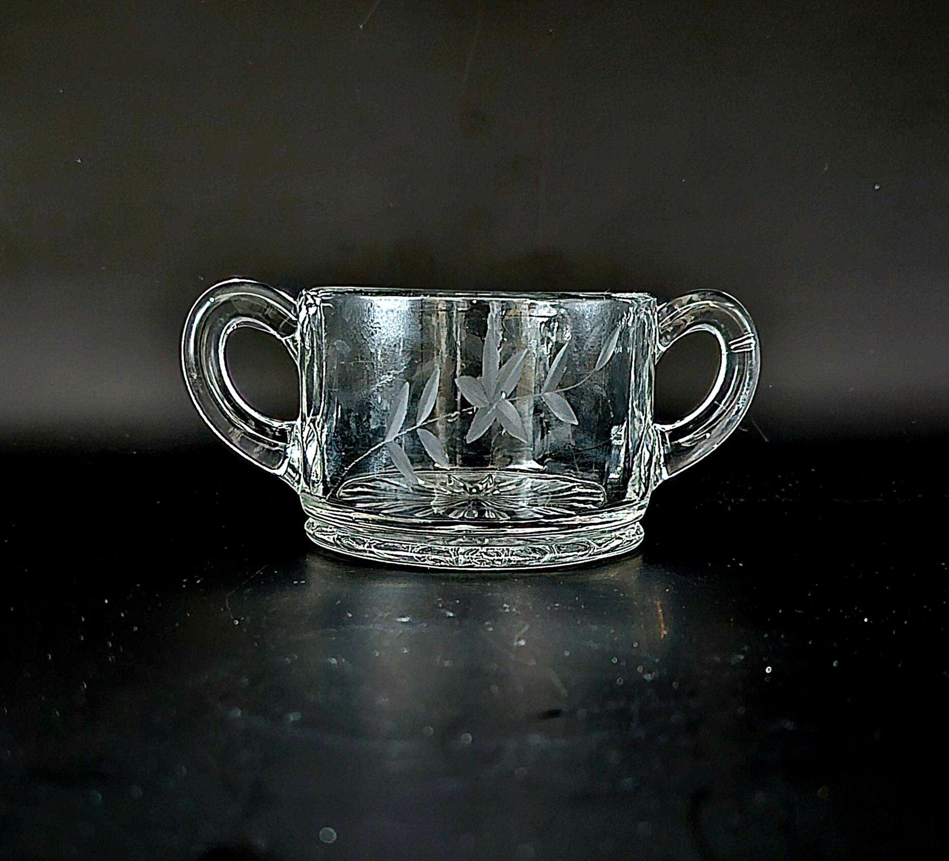 Vintage double-handled sugar bowl, Heisey depression glass, etched with a flower with stem and small leaves.