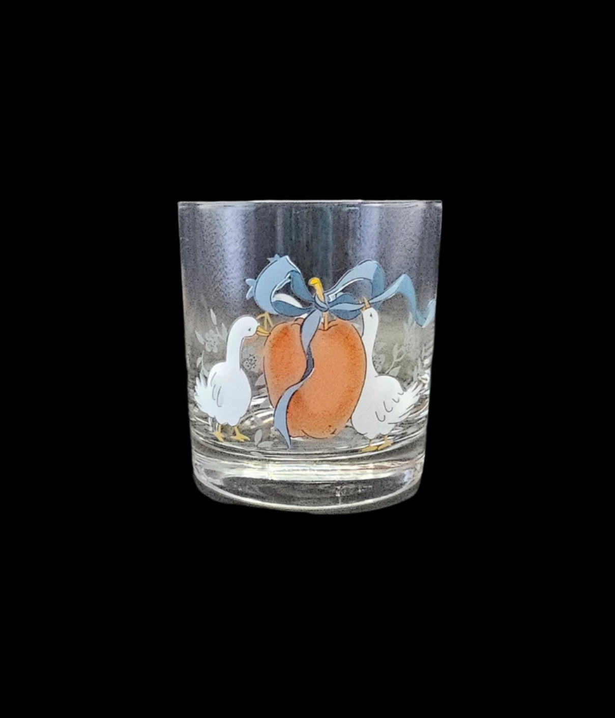 8 oz Double Old Fashioned Tumbler or Juice Glass, International Tableworks Marmalade Pattern. Picture shows glasswith two white geese, a large red apple, and a blue ribbon tied around the stem of the apple.